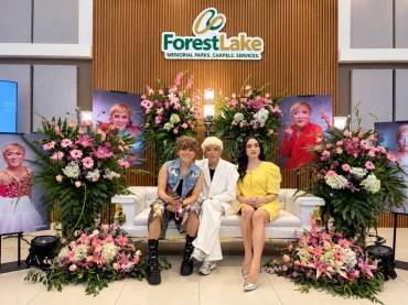 Three guests beneath the Forest Lake logo